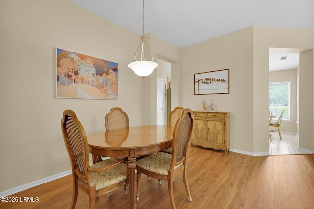 dining room with baseboards, visible vents, and light wood-style flooring