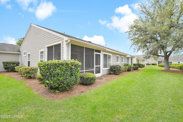 back of property featuring a lawn and a sunroom