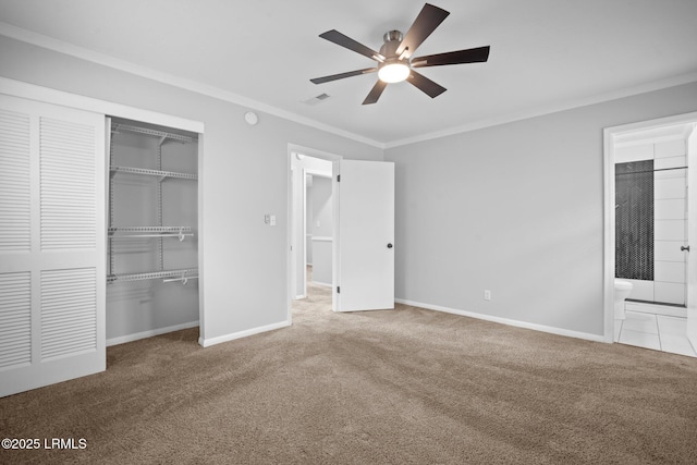 unfurnished bedroom featuring carpet flooring, a closet, crown molding, and baseboards