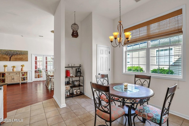 128 Colvin Dr, Okatie, SC 29909 - dining area featuring a high ceiling, light tile patterned flooring, a notable chandelier, and plenty of natural light