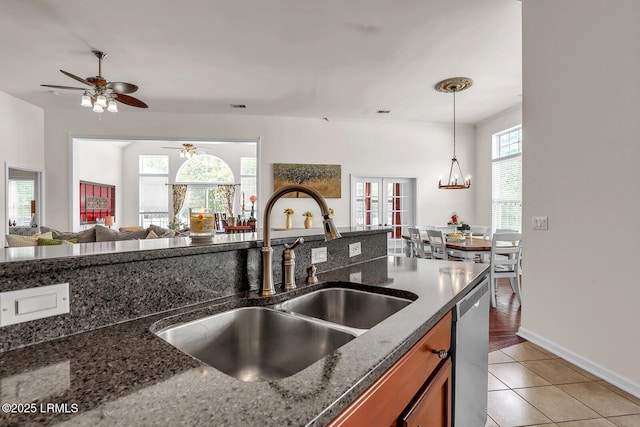128 Colvin Dr, Okatie, SC 29909 - kitchen featuring light tile patterned floors, brown cabinets, dark stone counters, dishwasher, and a sink
