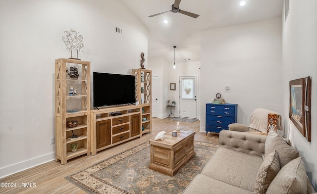 living room featuring ceiling fan, high vaulted ceiling, and light wood-type flooring