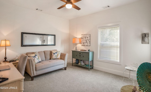 carpeted living room with ceiling fan