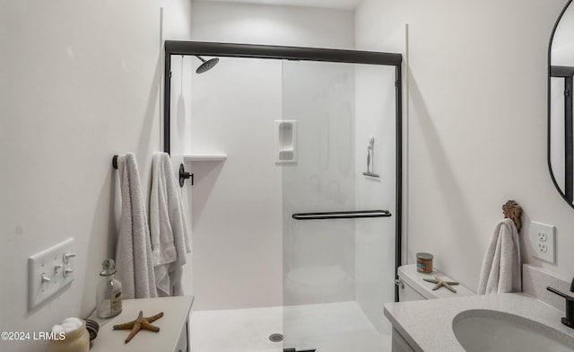 bathroom with vanity, a shower with door, and toilet