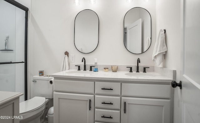 bathroom with vanity, toilet, and a shower with shower door