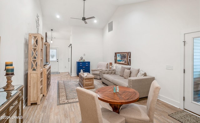 living room featuring high vaulted ceiling, light hardwood / wood-style floors, and ceiling fan