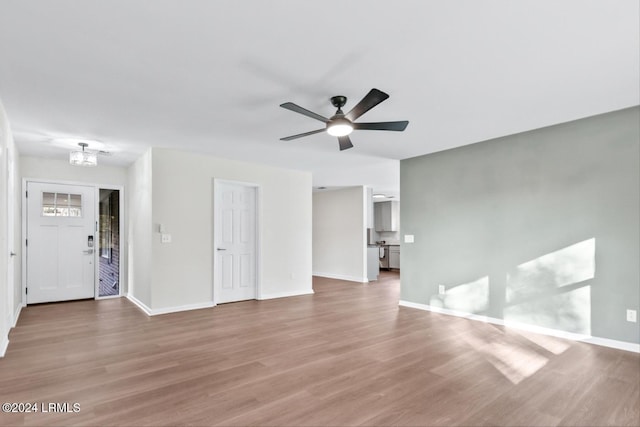 unfurnished living room with hardwood / wood-style flooring and ceiling fan with notable chandelier