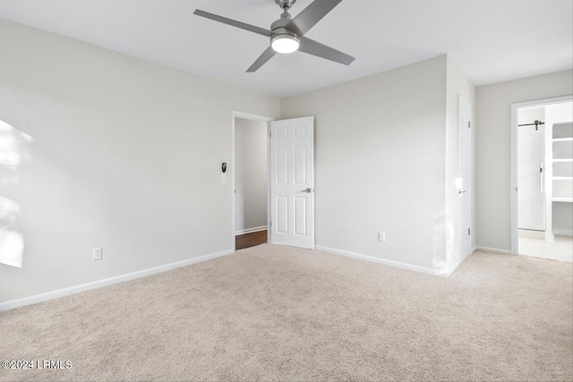 unfurnished room with light colored carpet and ceiling fan