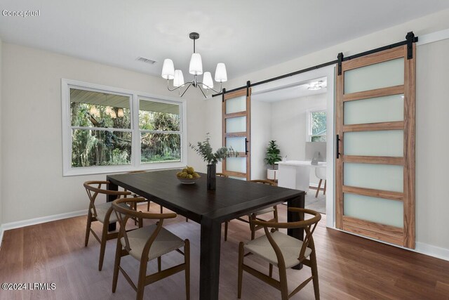 dining space with a healthy amount of sunlight, a barn door, dark hardwood / wood-style floors, and an inviting chandelier