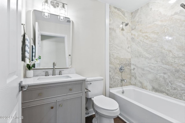 full bathroom featuring tiled shower / bath, vanity, and toilet