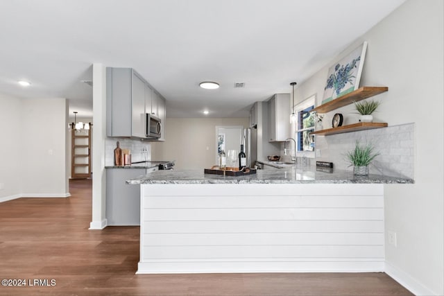 kitchen with sink, dark wood-type flooring, gray cabinetry, stainless steel appliances, and kitchen peninsula