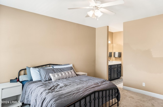 bedroom with connected bathroom, light colored carpet, and ceiling fan