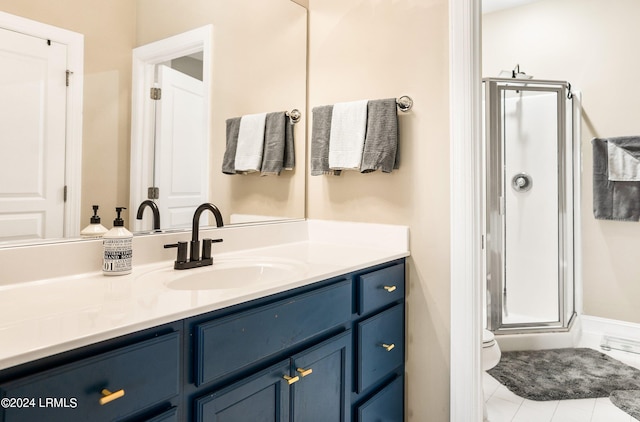 bathroom featuring vanity, a shower with shower door, tile patterned floors, and toilet