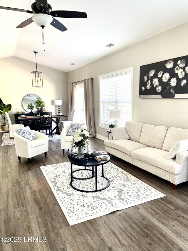 living room with lofted ceiling, ceiling fan with notable chandelier, and wood-type flooring