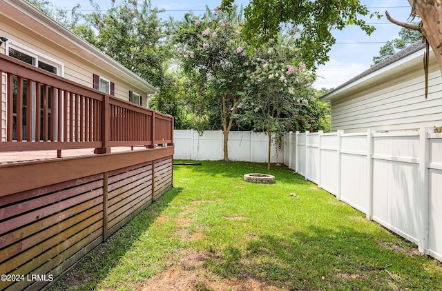 view of yard featuring an outdoor fire pit and a deck