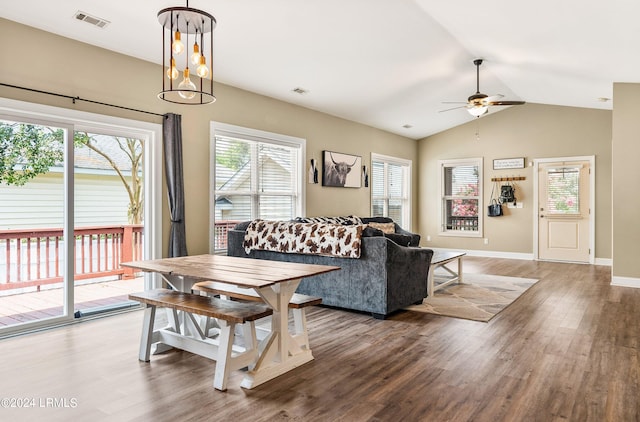 living room featuring hardwood / wood-style flooring, vaulted ceiling, and ceiling fan with notable chandelier