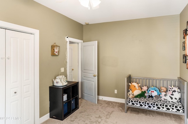 bedroom featuring light colored carpet, a closet, and ceiling fan