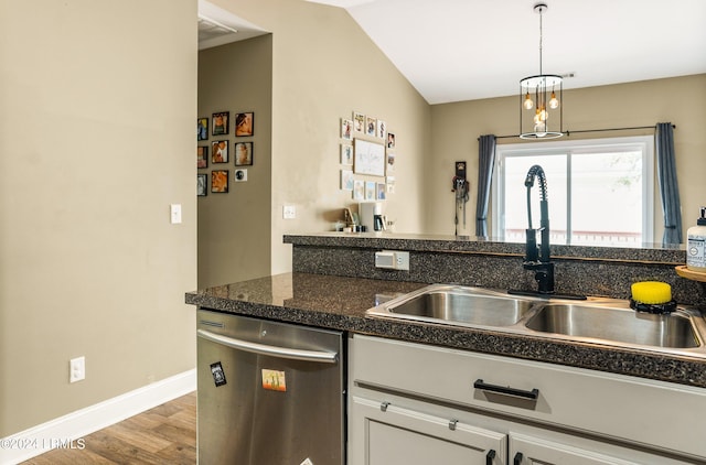 kitchen with hardwood / wood-style floors, pendant lighting, lofted ceiling, sink, and stainless steel dishwasher