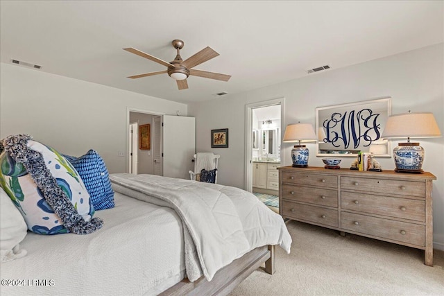 bedroom with light colored carpet, ceiling fan, and ensuite bathroom