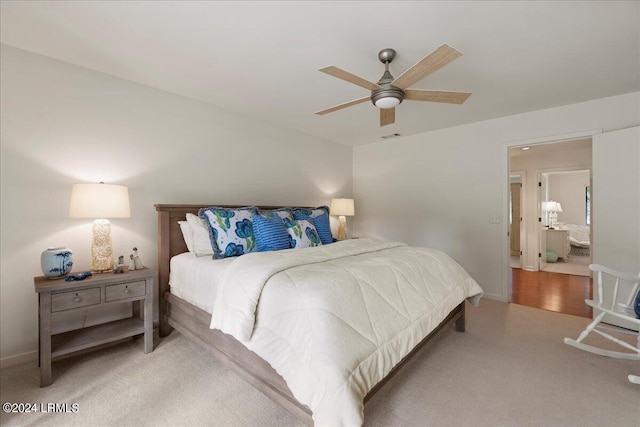 carpeted bedroom featuring ensuite bath and ceiling fan