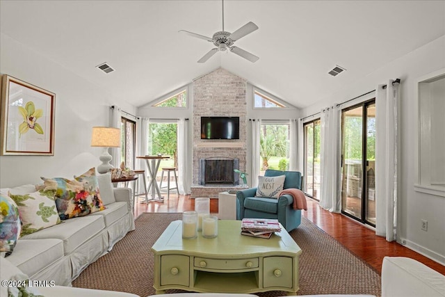 living room with dark wood-type flooring, ceiling fan, a fireplace, and vaulted ceiling