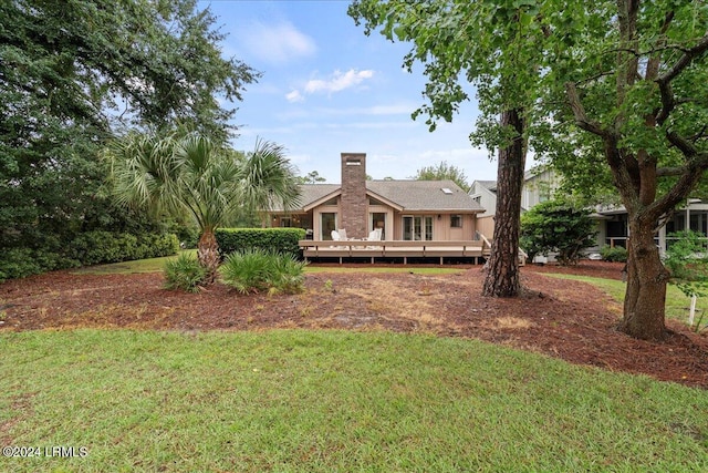 back of house with a wooden deck and a lawn