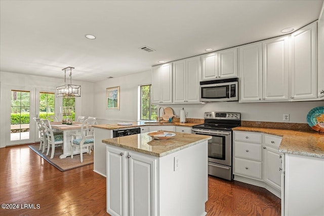 kitchen with pendant lighting, white cabinetry, appliances with stainless steel finishes, and a kitchen island