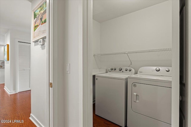 clothes washing area featuring washing machine and dryer and dark hardwood / wood-style floors