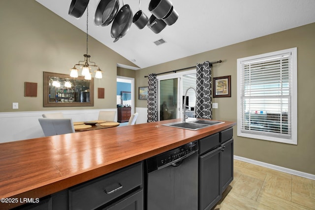 kitchen featuring pendant lighting, butcher block countertops, dishwasher, lofted ceiling, and sink