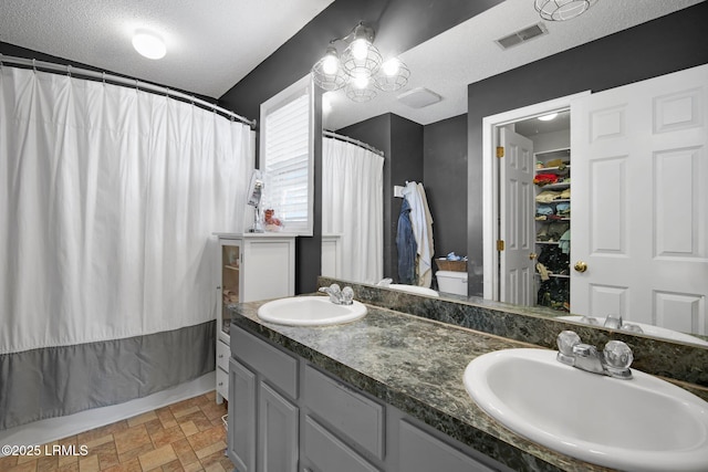 bathroom with a shower with curtain, vanity, and a textured ceiling