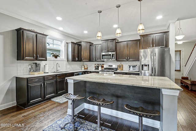 296 Hulston Landing Rd, Bluffton, SC 29909 - kitchen featuring appliances with stainless steel finishes, dark brown cabinetry, a breakfast bar, light stone countertops, and a kitchen island