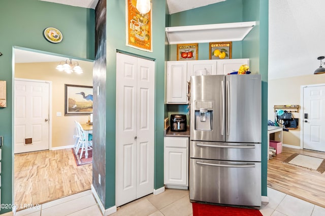 6 Wegeon Ln, Beaufort, SC 29906 - kitchen featuring stainless steel fridge, white cabinetry, light tile patterned flooring, and a chandelier