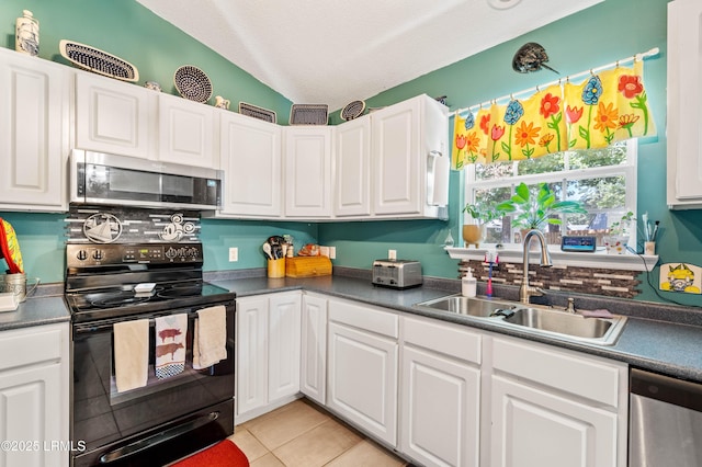 6 Wegeon Ln, Beaufort, SC 29906 - kitchen featuring appliances with stainless steel finishes, vaulted ceiling, white cabinets, dark countertops, and a textured ceiling