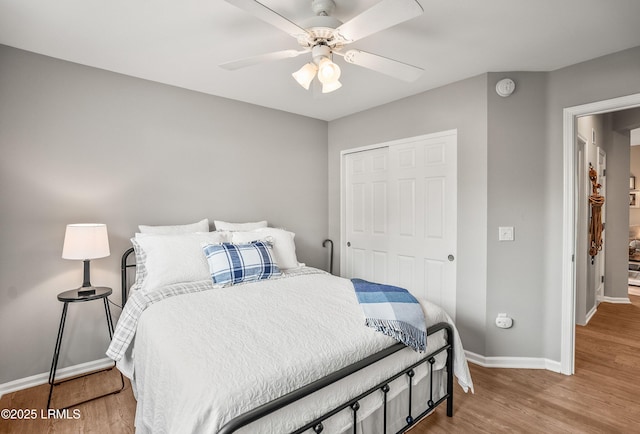 bedroom with wood-type flooring, ceiling fan, and a closet