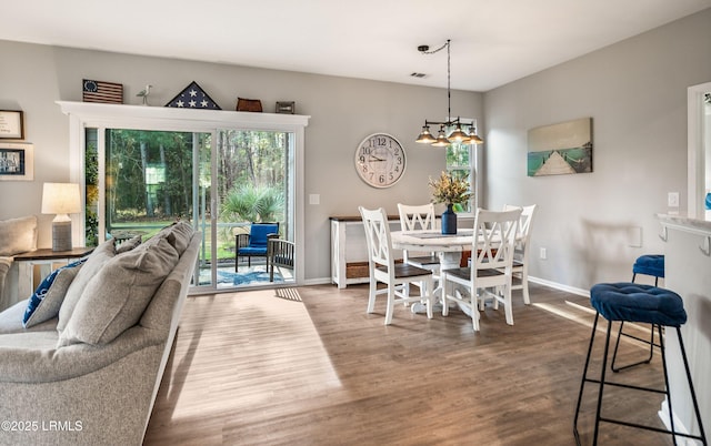 dining area featuring hardwood / wood-style floors and a chandelier