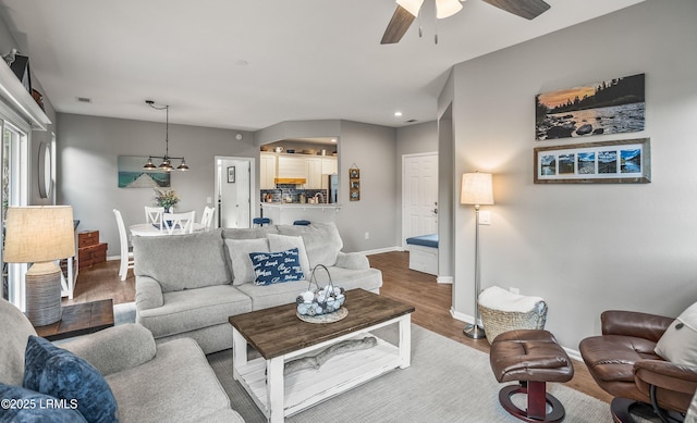 living room featuring wood-type flooring and ceiling fan