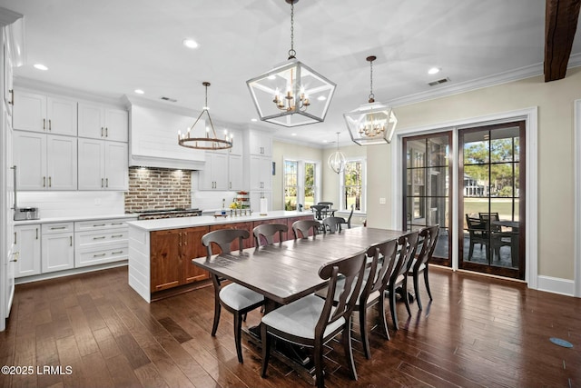 dining area featuring dark hardwood / wood-style flooring, a notable chandelier, and ornamental molding