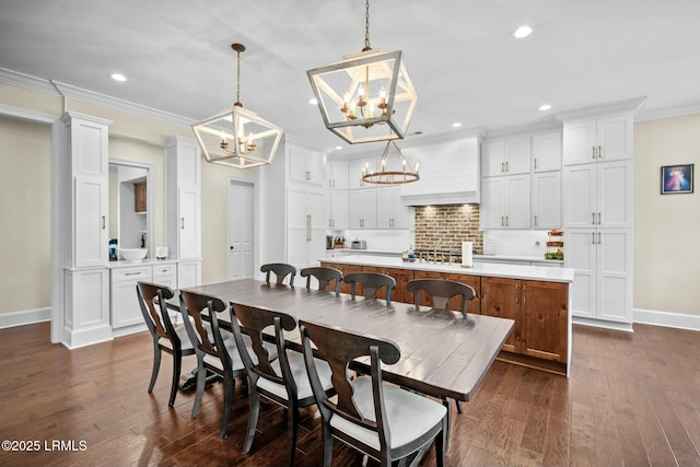 dining space with dark hardwood / wood-style flooring, crown molding, and an inviting chandelier