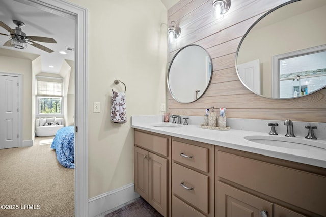 bathroom featuring ceiling fan, vanity, and wood walls