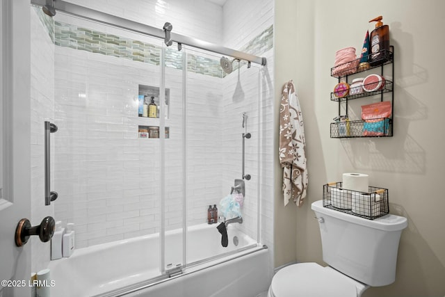 bathroom with toilet and shower / bath combination with glass door