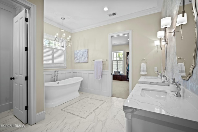 bathroom featuring vanity, a notable chandelier, crown molding, and a bathing tub