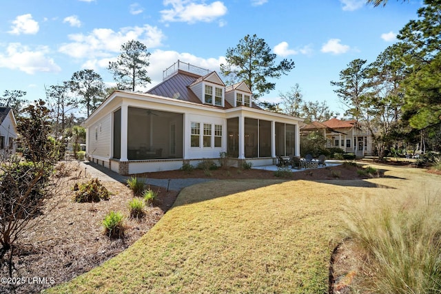 rear view of property with a sunroom and a yard