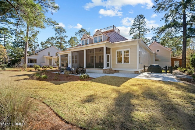 rear view of house with a yard, a patio area, and a sunroom