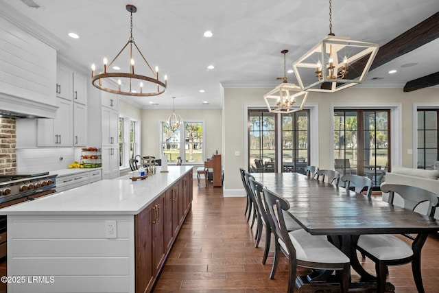 kitchen featuring a notable chandelier, decorative light fixtures, french doors, and a large island with sink