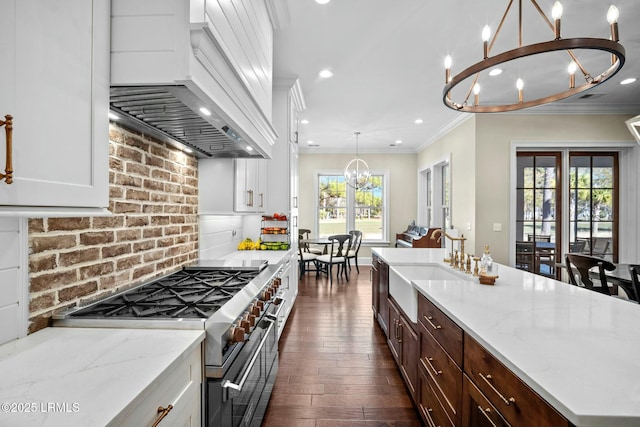 kitchen with white cabinetry, backsplash, a notable chandelier, custom range hood, and range with two ovens