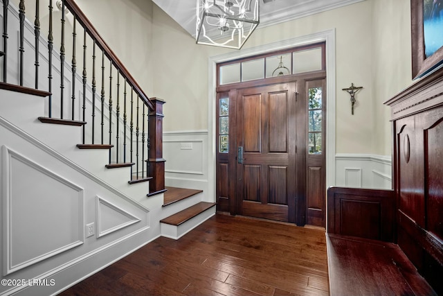 entryway featuring a notable chandelier, ornamental molding, and dark hardwood / wood-style floors