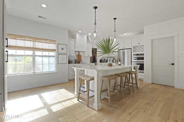 5 Canebrake Ln, Bluffton, SC 29910 - kitchen featuring appliances with stainless steel finishes, recessed lighting, white cabinetry, a breakfast bar area, and light countertops