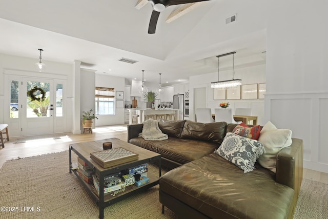 5 Canebrake Ln, Bluffton, SC 29910 - living room with a ceiling fan, light wood-type flooring, a decorative wall, high vaulted ceiling, and wainscoting