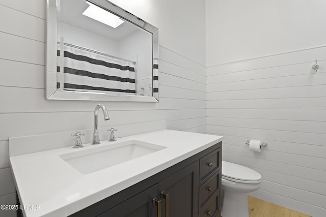 5 Canebrake Ln, Bluffton, SC 29910 - bathroom with vanity, wood finished floors, wooden walls, and toilet