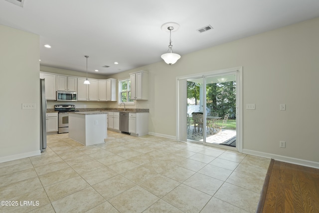 5 Junction Way, Bluffton, SC 29910 - kitchen featuring appliances with stainless steel finishes, light tile patterned flooring, a kitchen island, baseboards, and hanging light fixtures